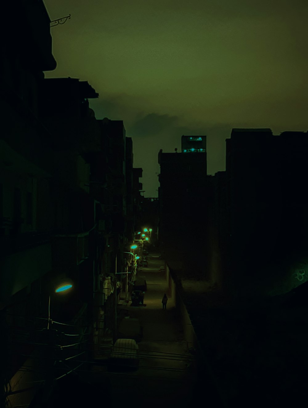 a dark city street at night with buildings lit up