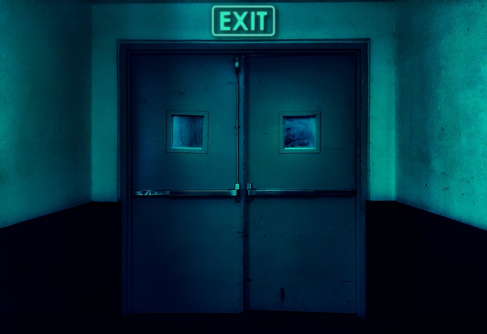Un segnale di uscita sopra una porta in una stanza buia