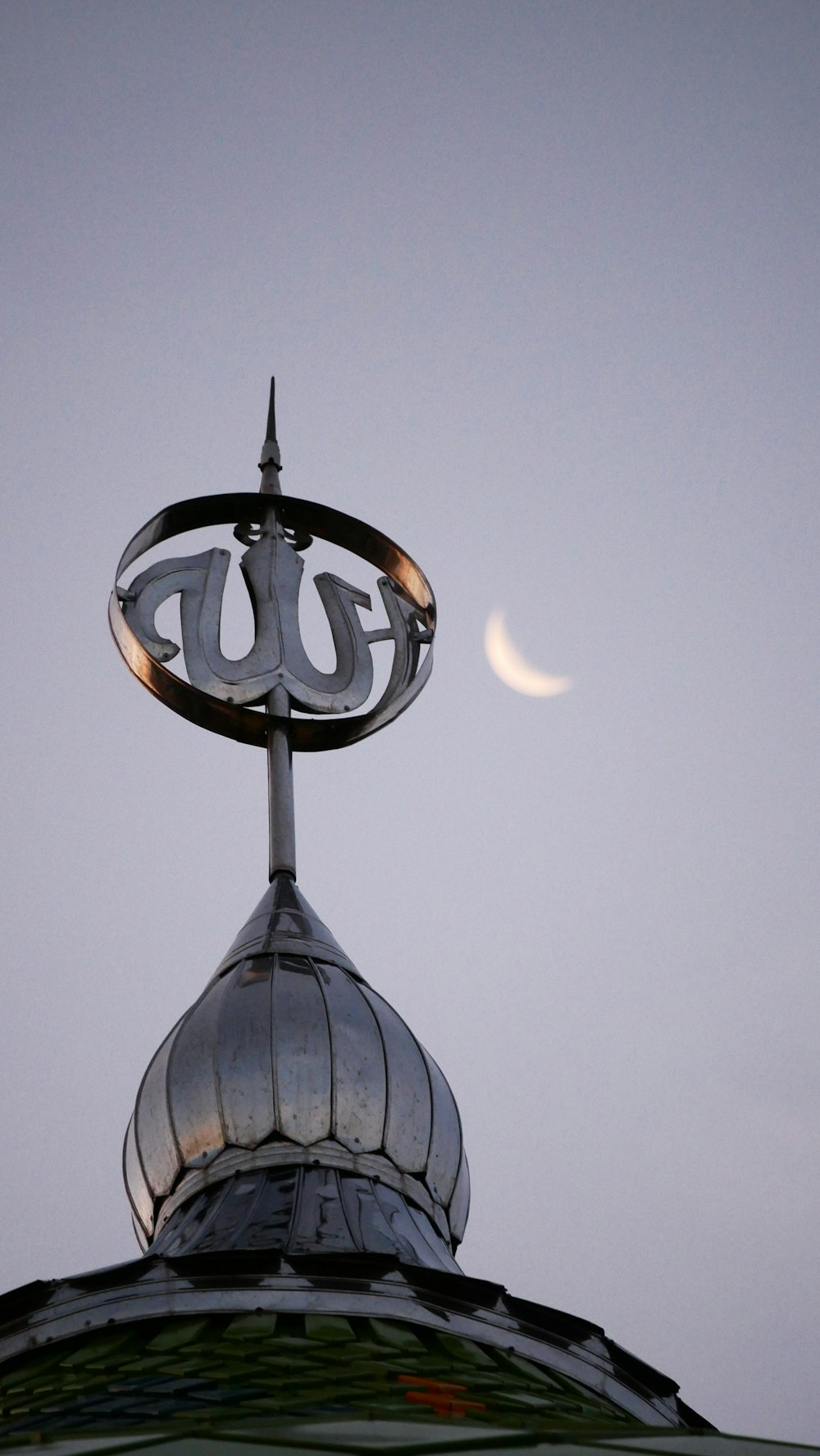 a clock on top of a building with the moon in the background
