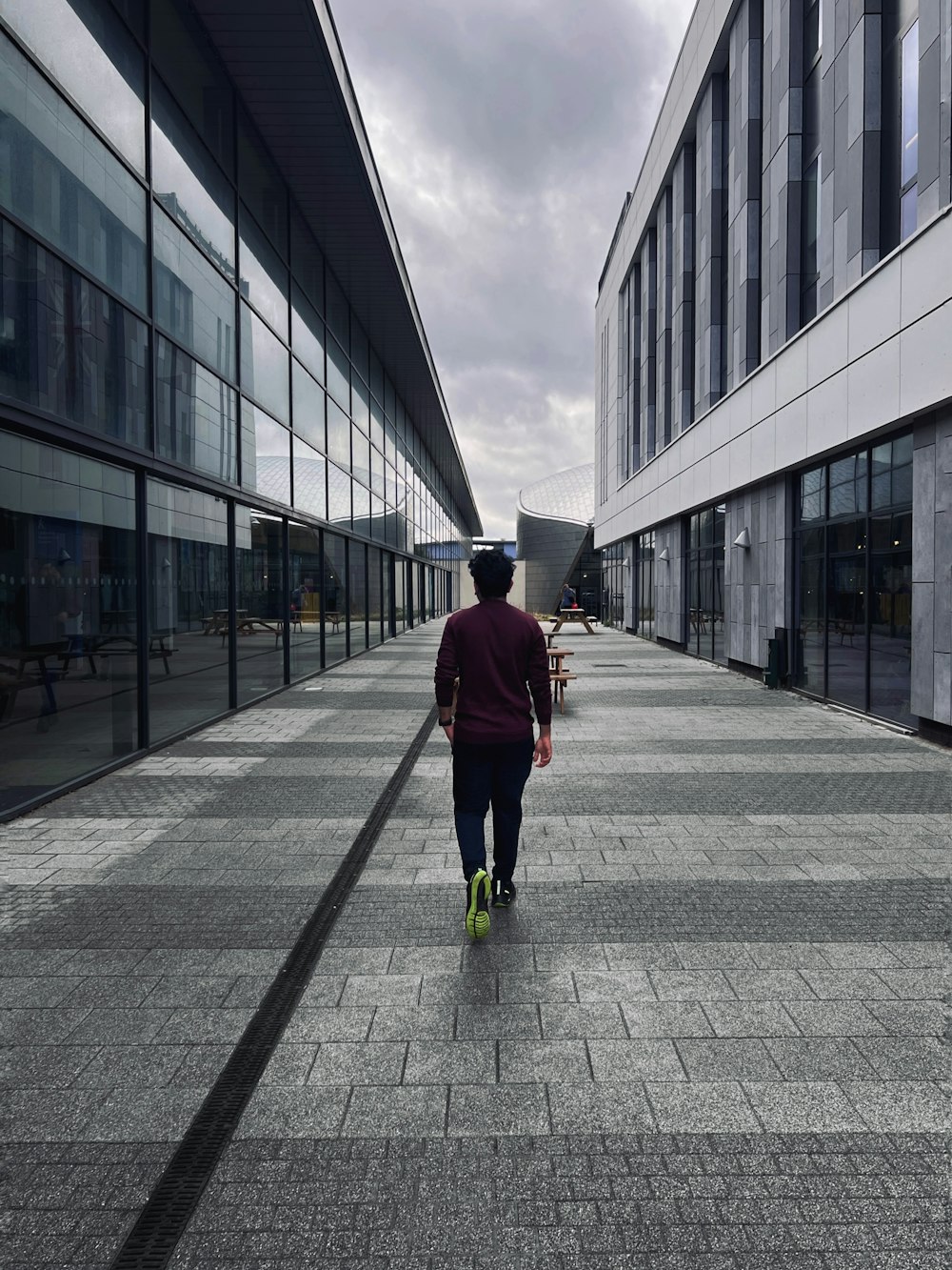 a man walking down a sidewalk in front of a building