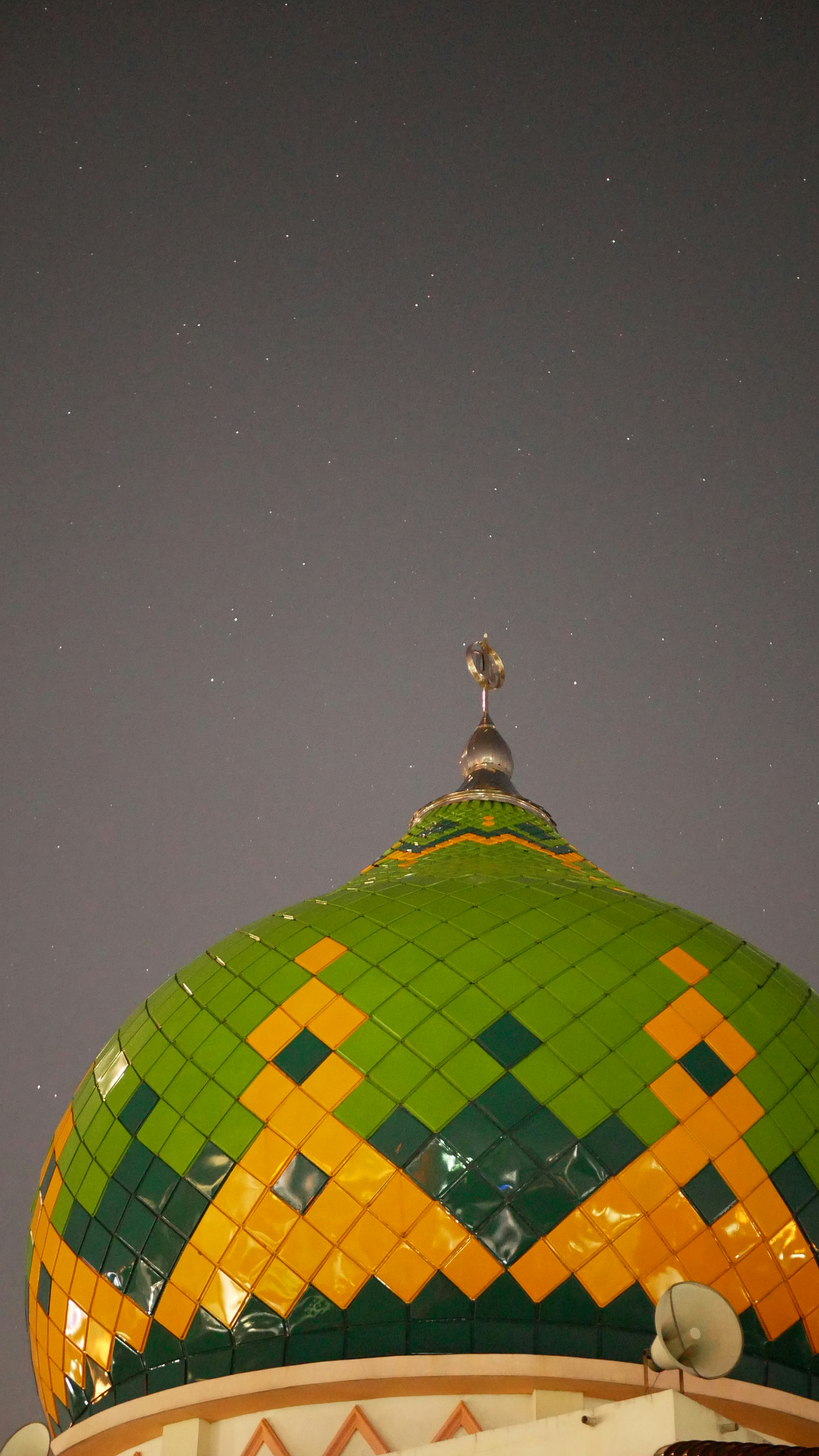 a green and yellow tiled dome on top of a building
