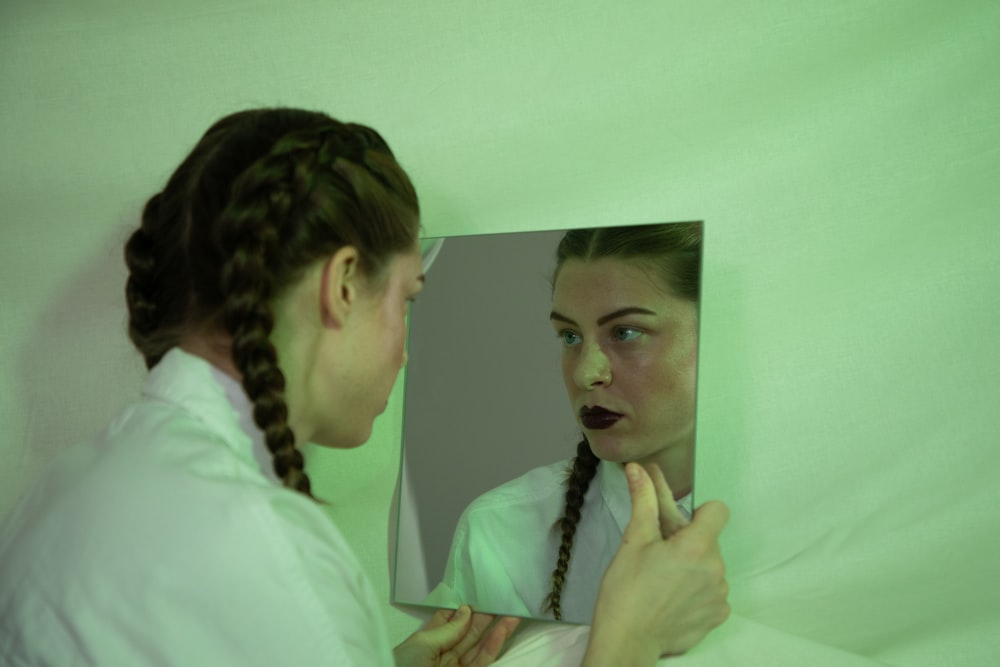 a woman looking at her reflection in a mirror