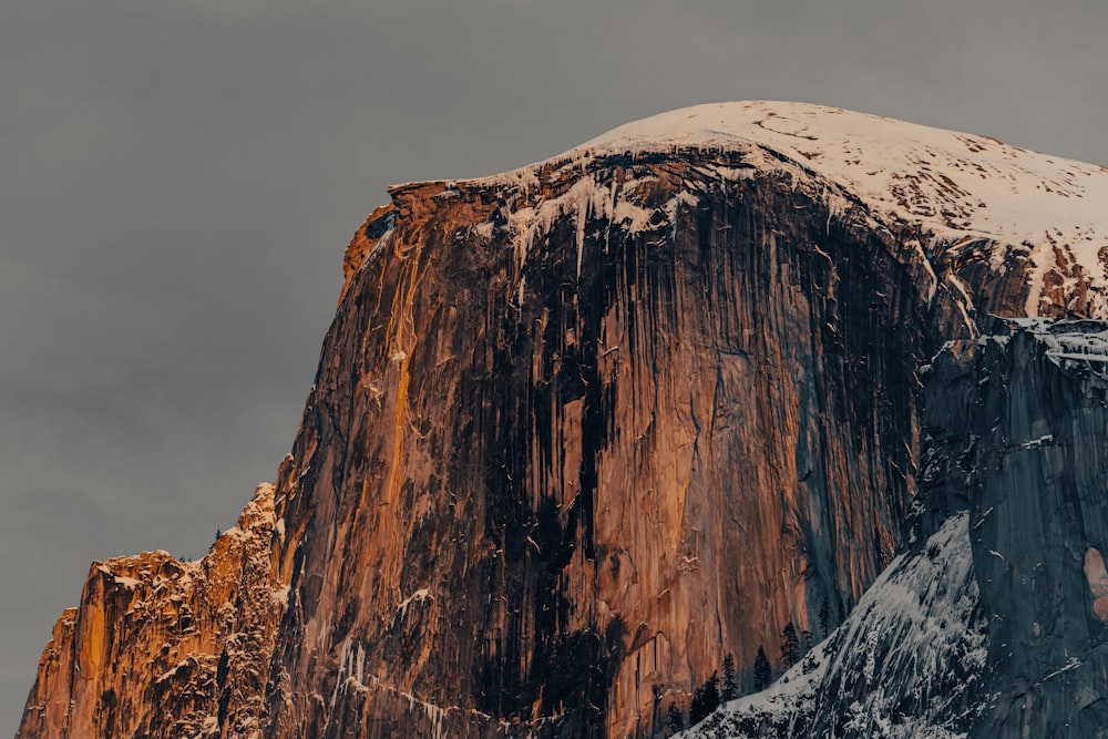 a tall mountain covered in snow under a cloudy sky