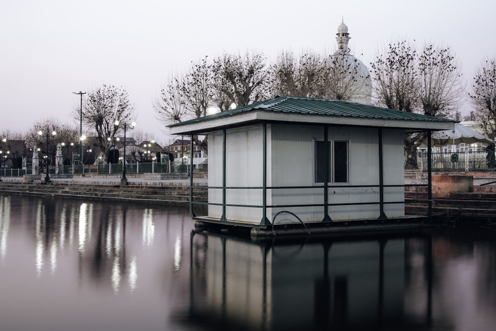 a small white building sitting on top of a lake