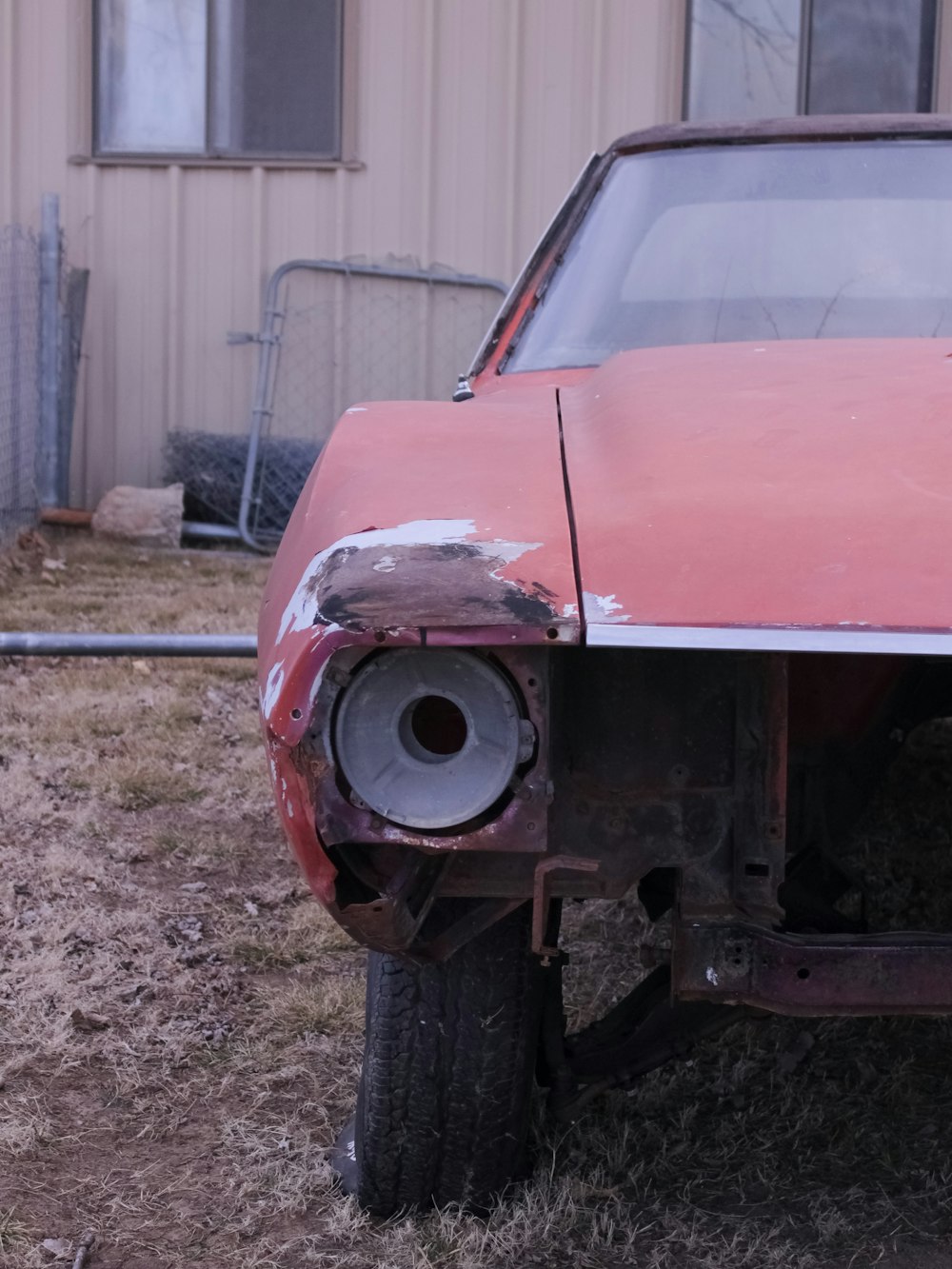 a rusted out car sitting in a yard