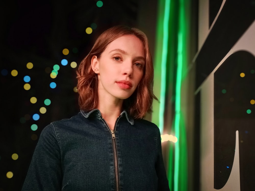 a woman standing in front of a green light