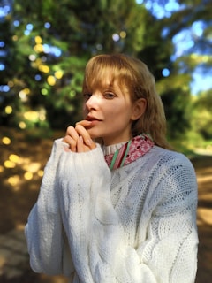 Model wearing a cozy sweater outdoors, sunlight catching the knit pattern beautifully.