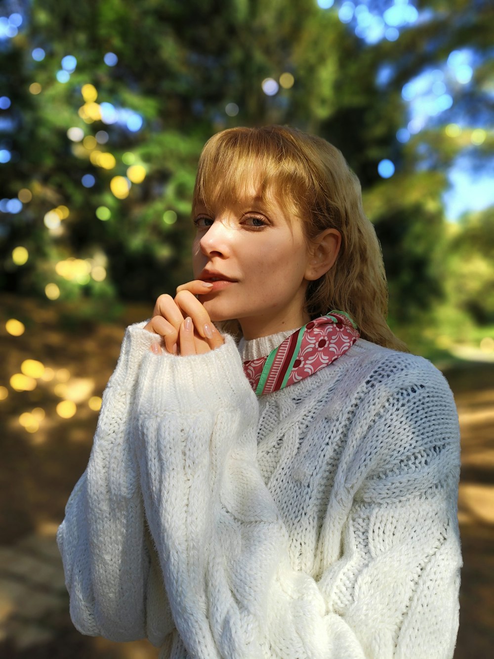 a woman in a white sweater posing for a picture