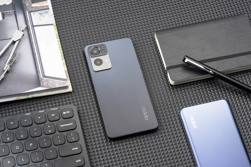 a cell phone sitting on top of a table next to a keyboard