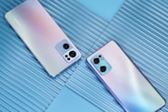 two new cell phones are laying side by side