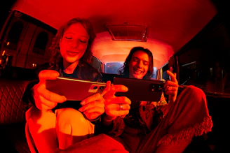 A driver and passenger smiling inside a car equipped with digital advertising and entertainment screens.