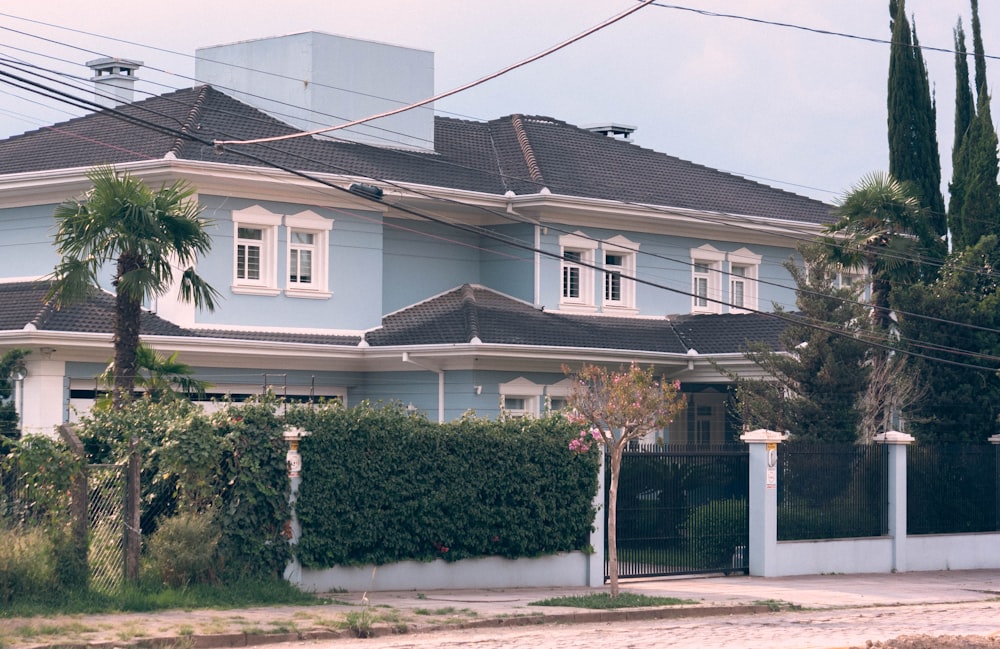 a large blue house with white trim and windows