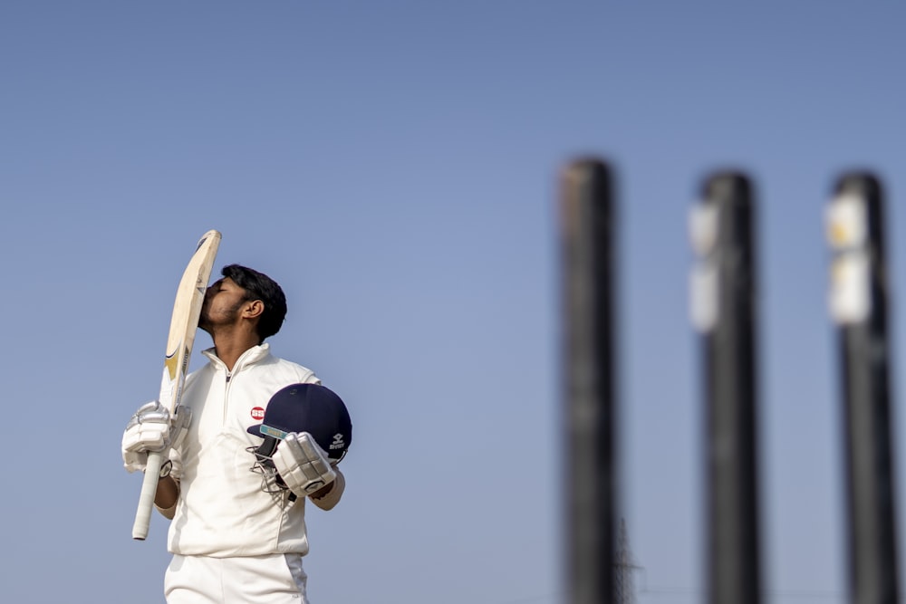 a man holding a bat and ball in his hands