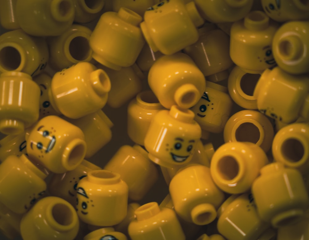a bunch of yellow legos with faces on them