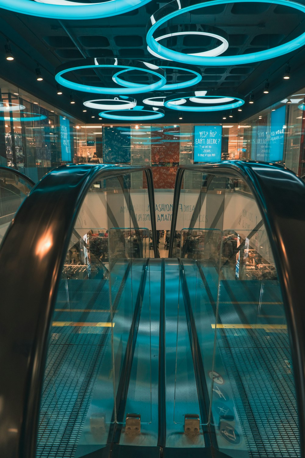 an escalator in a building with blue lights