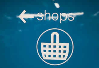 a blue sign with a shopping basket on it