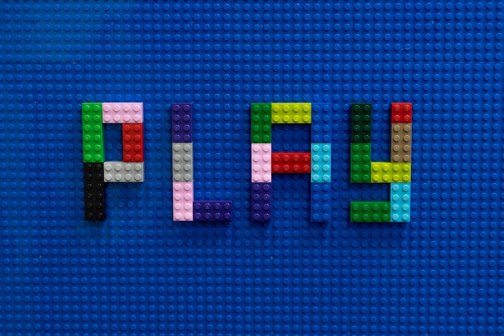 Das Wortspiel aus Legos auf blauer Oberfläche