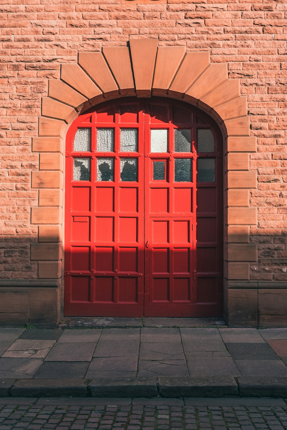 a brick building with a red door and window