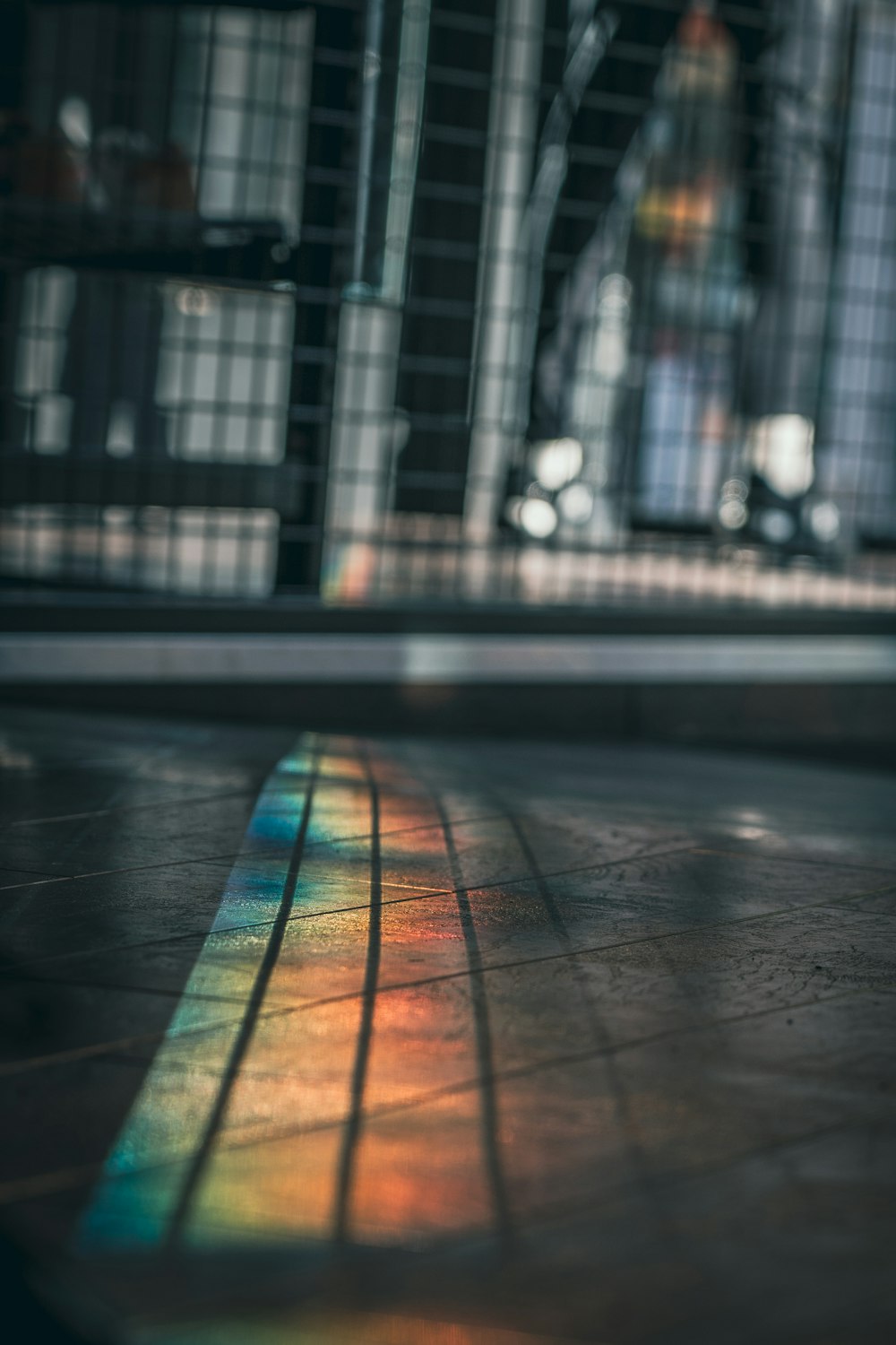 a rainbow colored light shines on a tiled floor