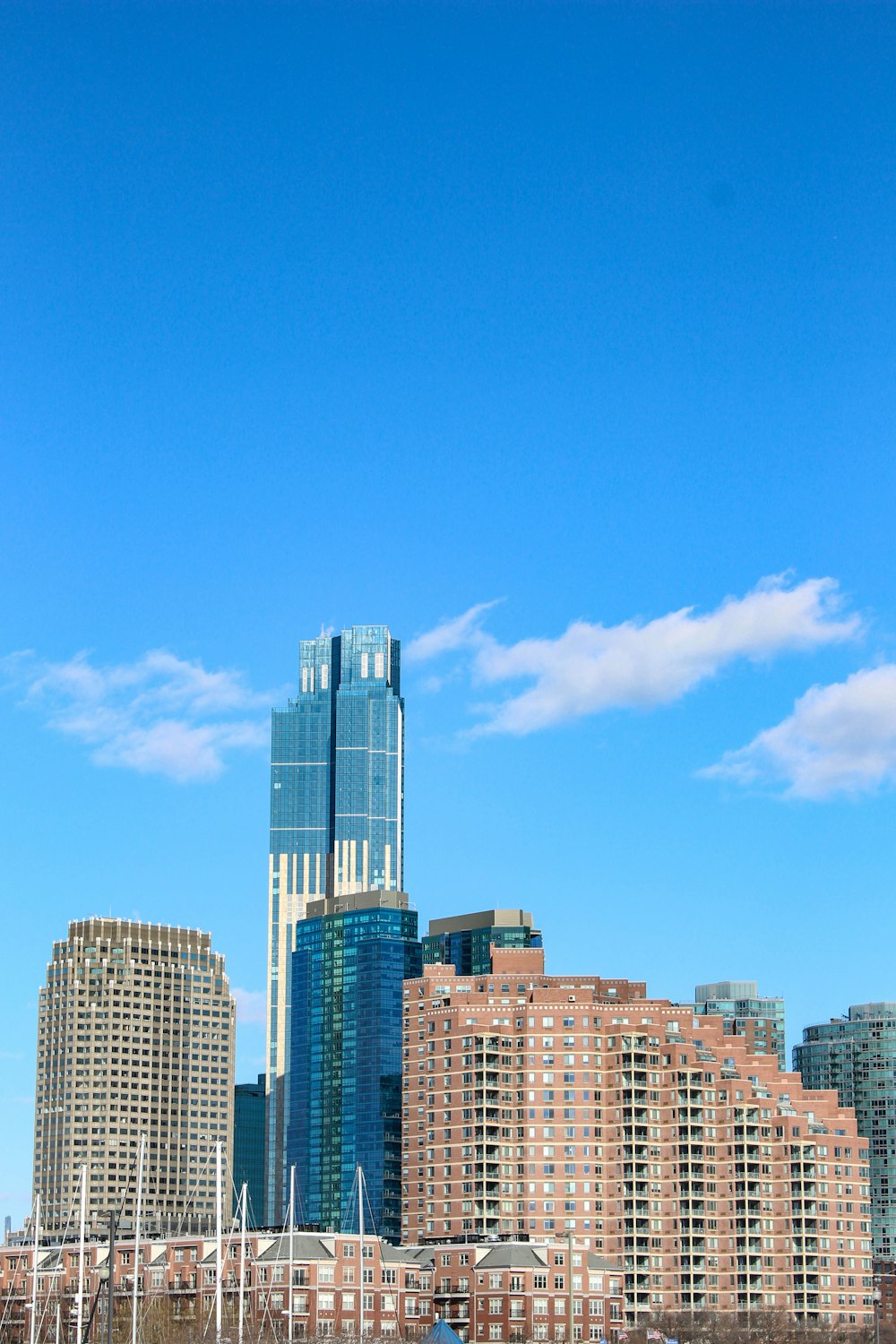 a city skyline with tall buildings and boats in the water