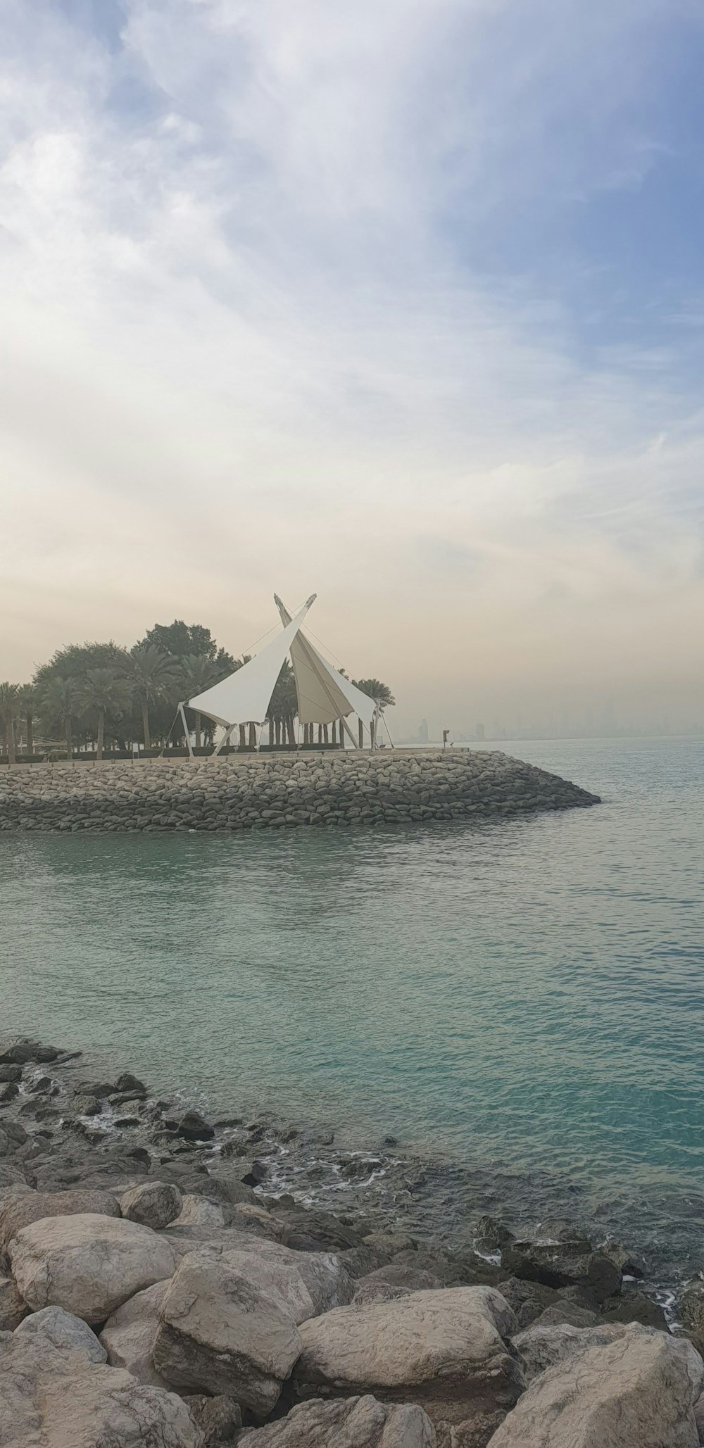 a teepee sitting on top of a beach next to the ocean