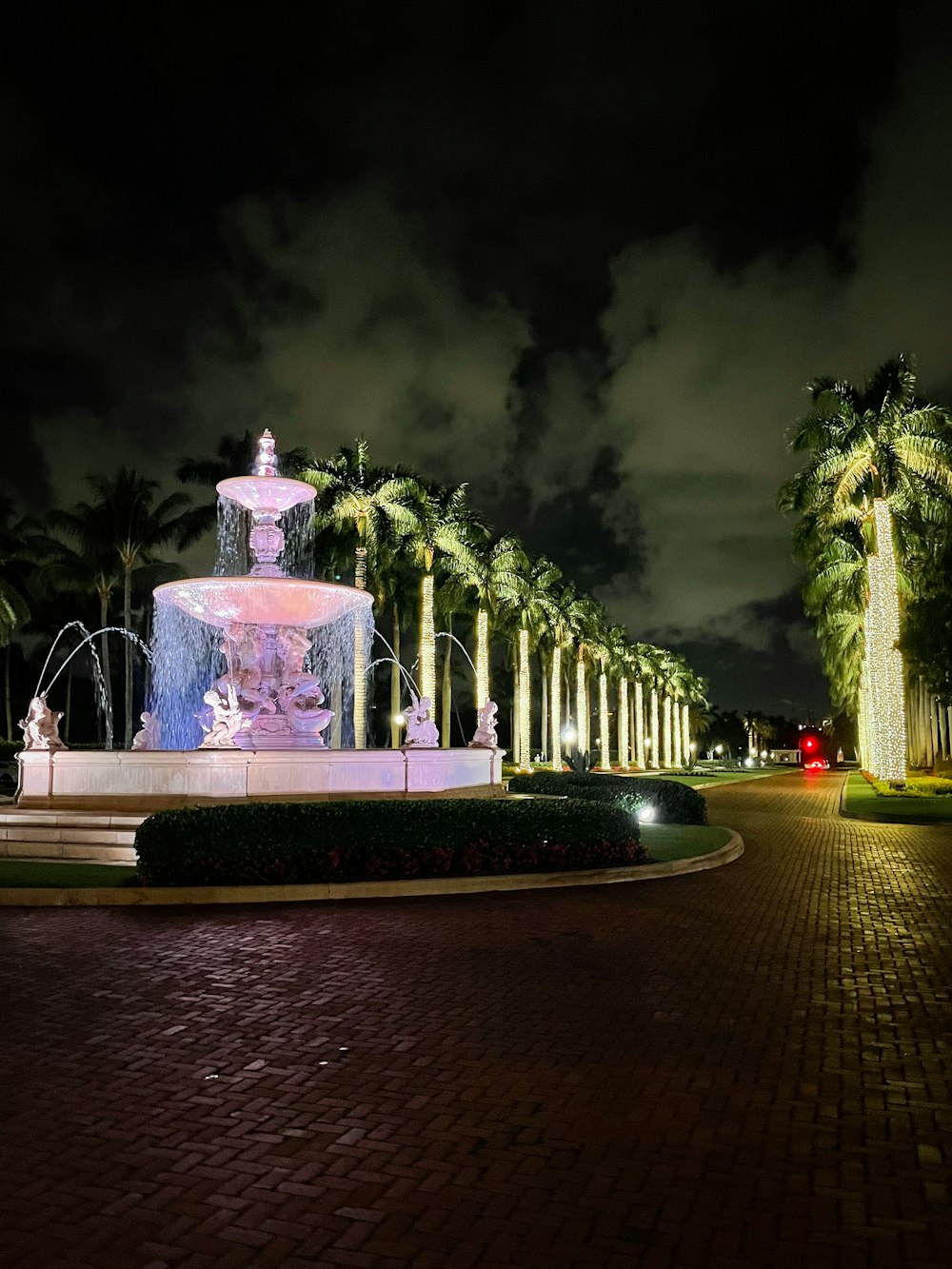 a fountain in the middle of a park at night