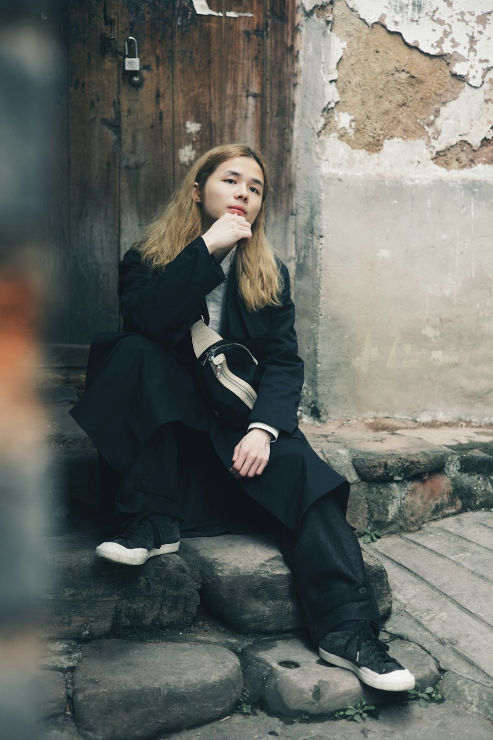 a woman sitting on the steps of a building