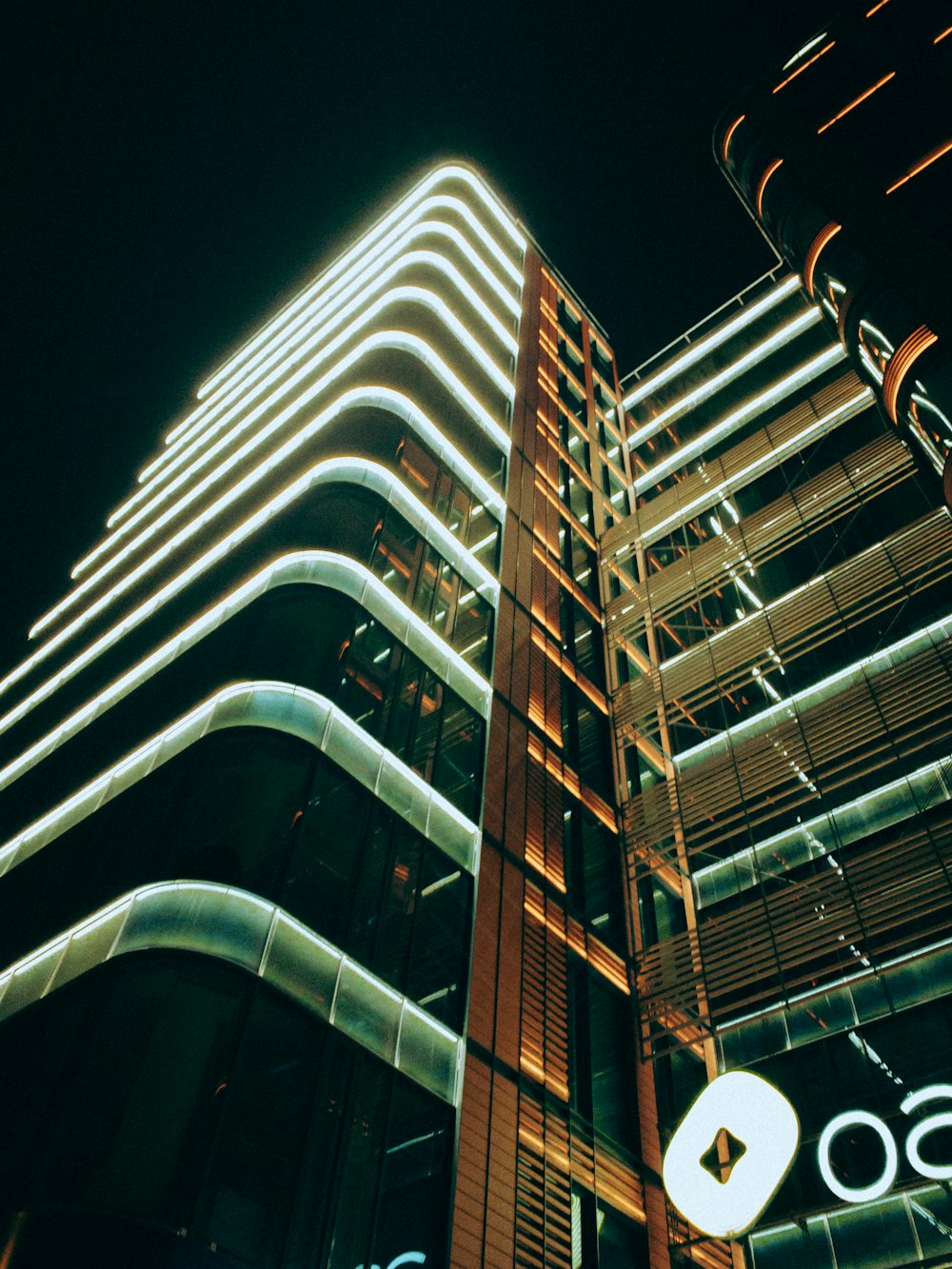 a very tall building with a lit up sign on it's side