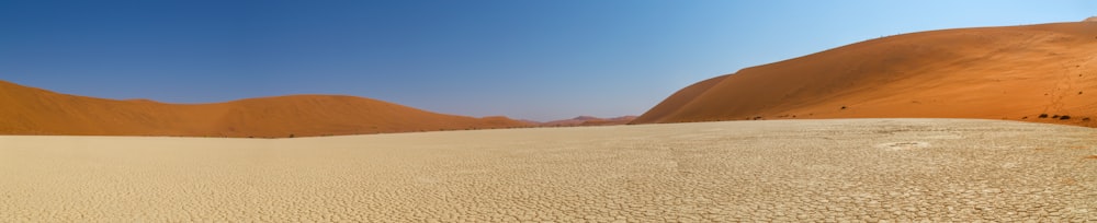 a group of people walking across a sandy desert