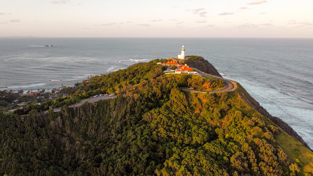 an aerial view of a lighthouse on top of a hill