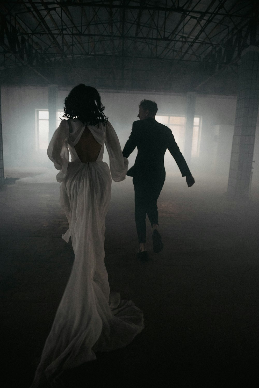 um homem e uma mulher em pé em um quarto escuro