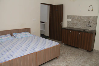 Cozy motel room featuring a minimalist design with warm lighting and a small kitchenette.