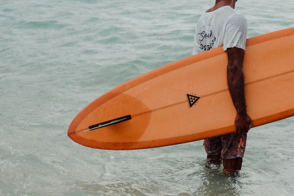 a man standing in the water holding a surfboard