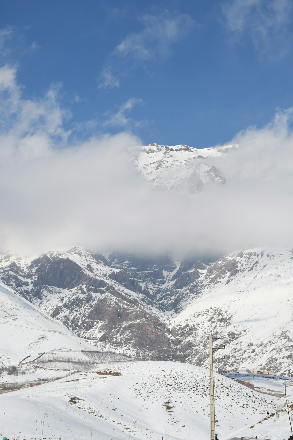 a mountain covered in snow under a cloudy sky