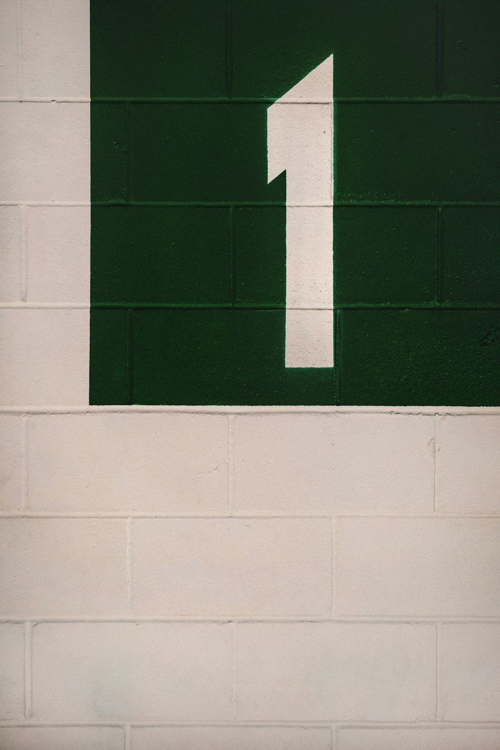 a green and white sign on a brick wall
