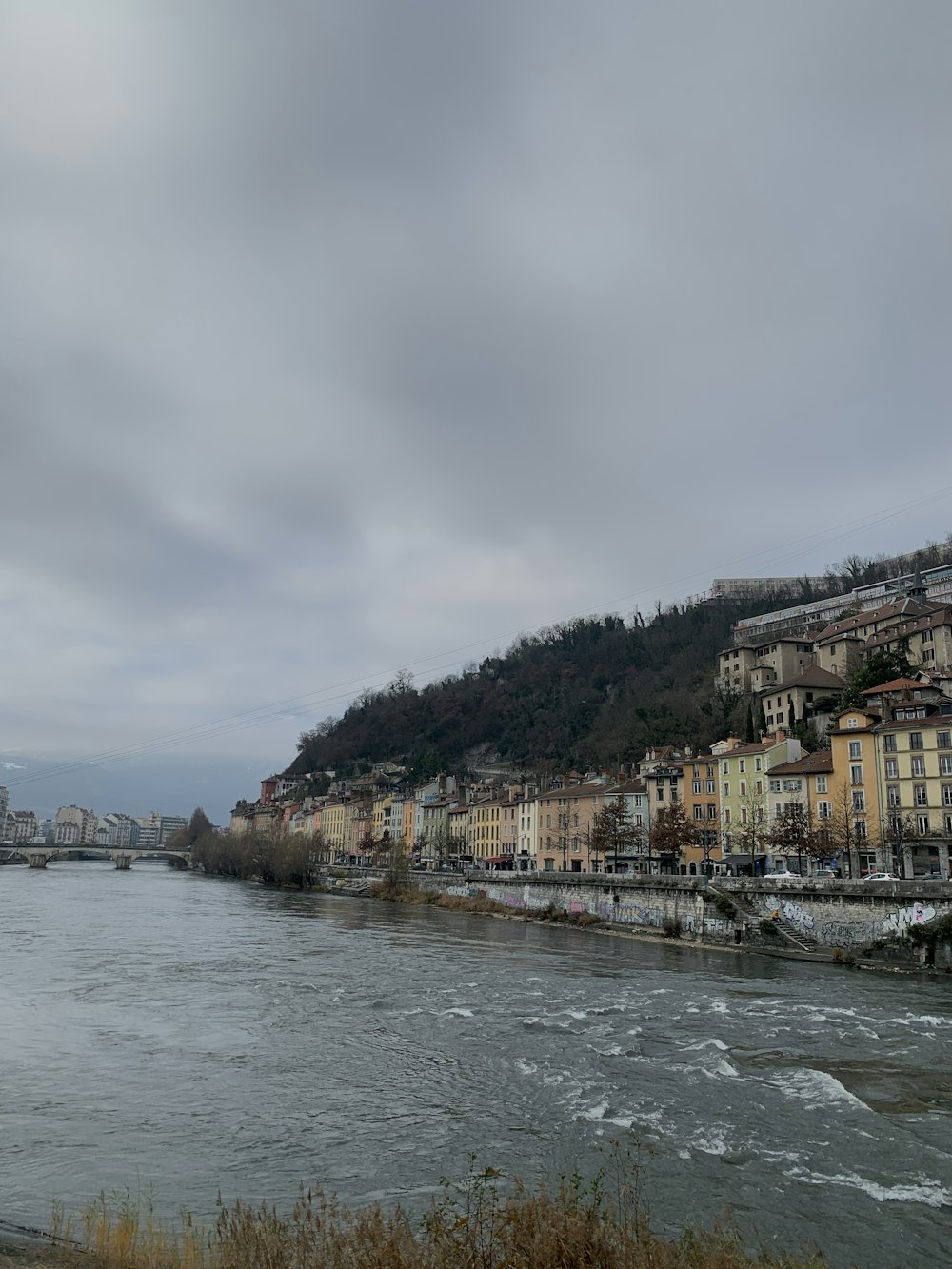 a body of water with buildings on a hill in the background