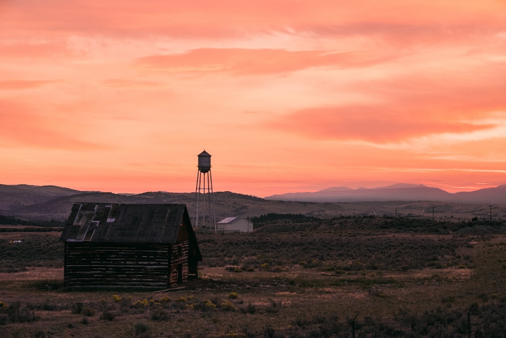 a barn and a water tower at sunset