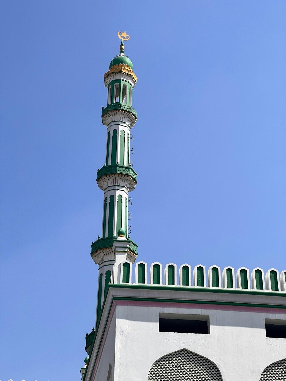 a tall green and white building with a clock on it's side