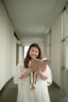 A young student holding books with a bright smile, symbolizing scholarship success.