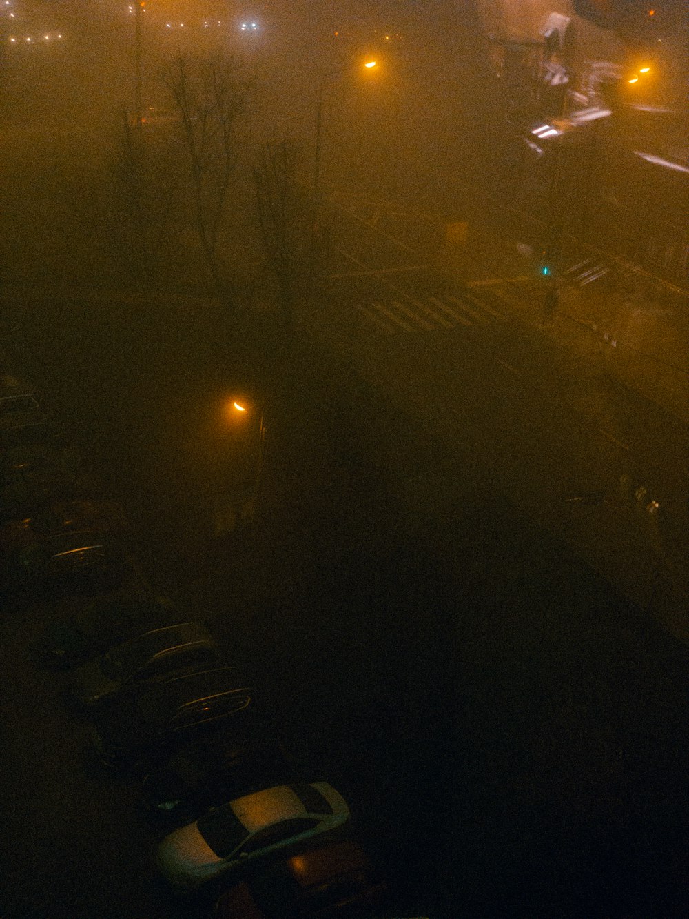 a parking lot filled with lots of cars on a foggy night