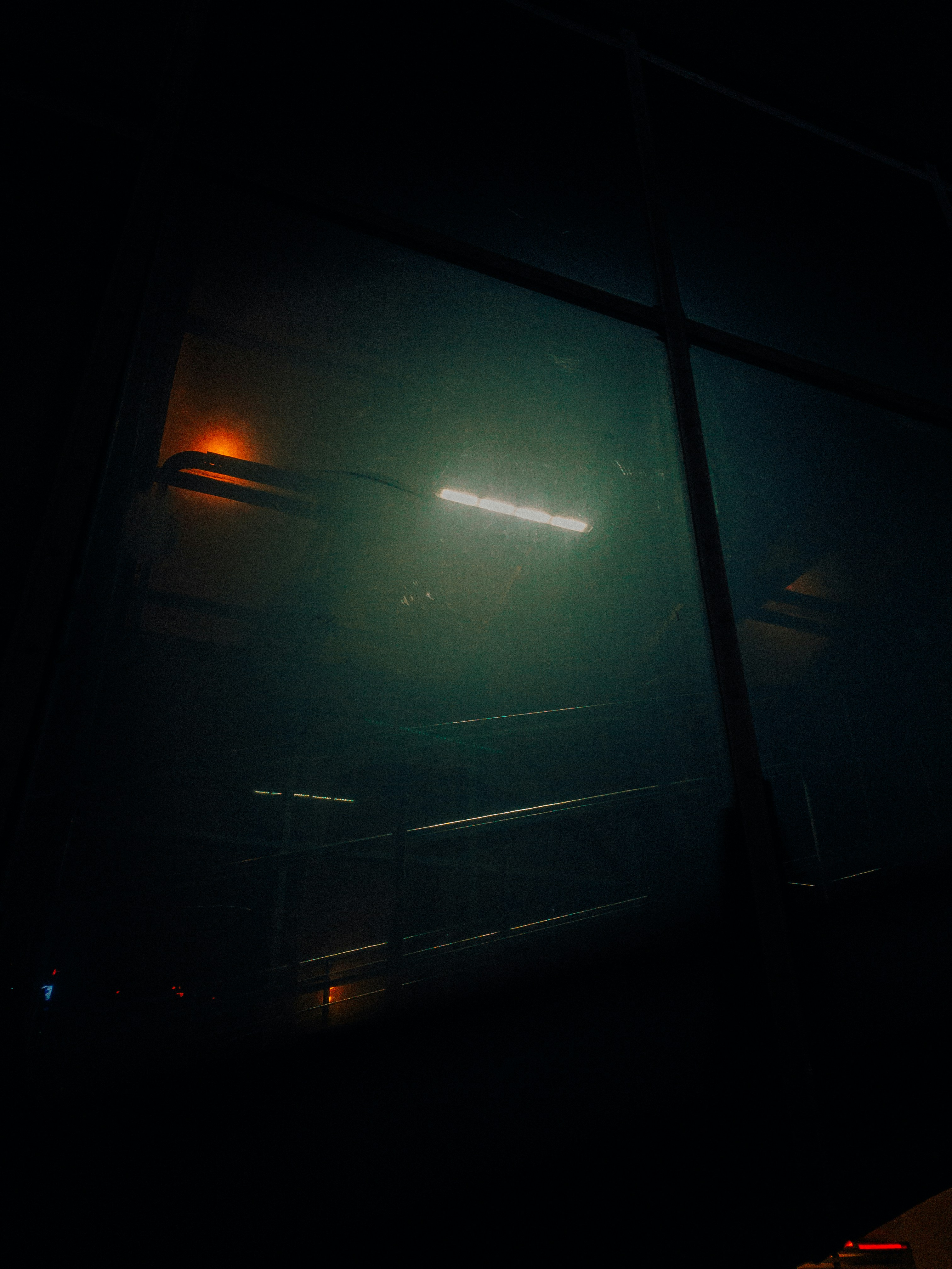 Una habitación oscura con una luz brillando a través de la ventana