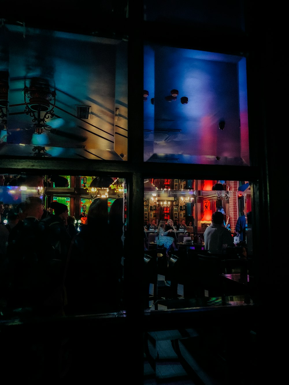 a group of people standing outside of a building at night