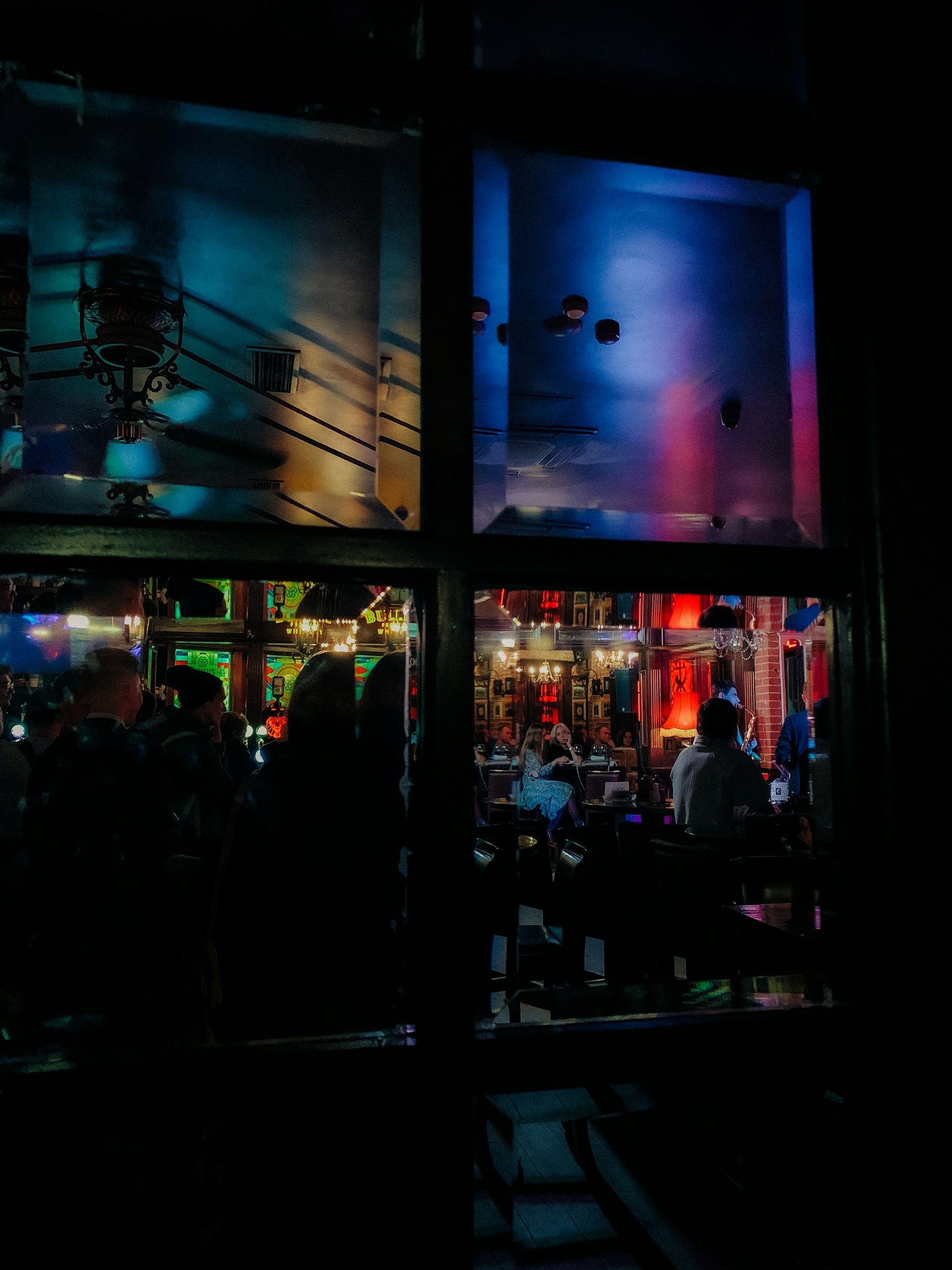 a group of people standing outside of a building at night