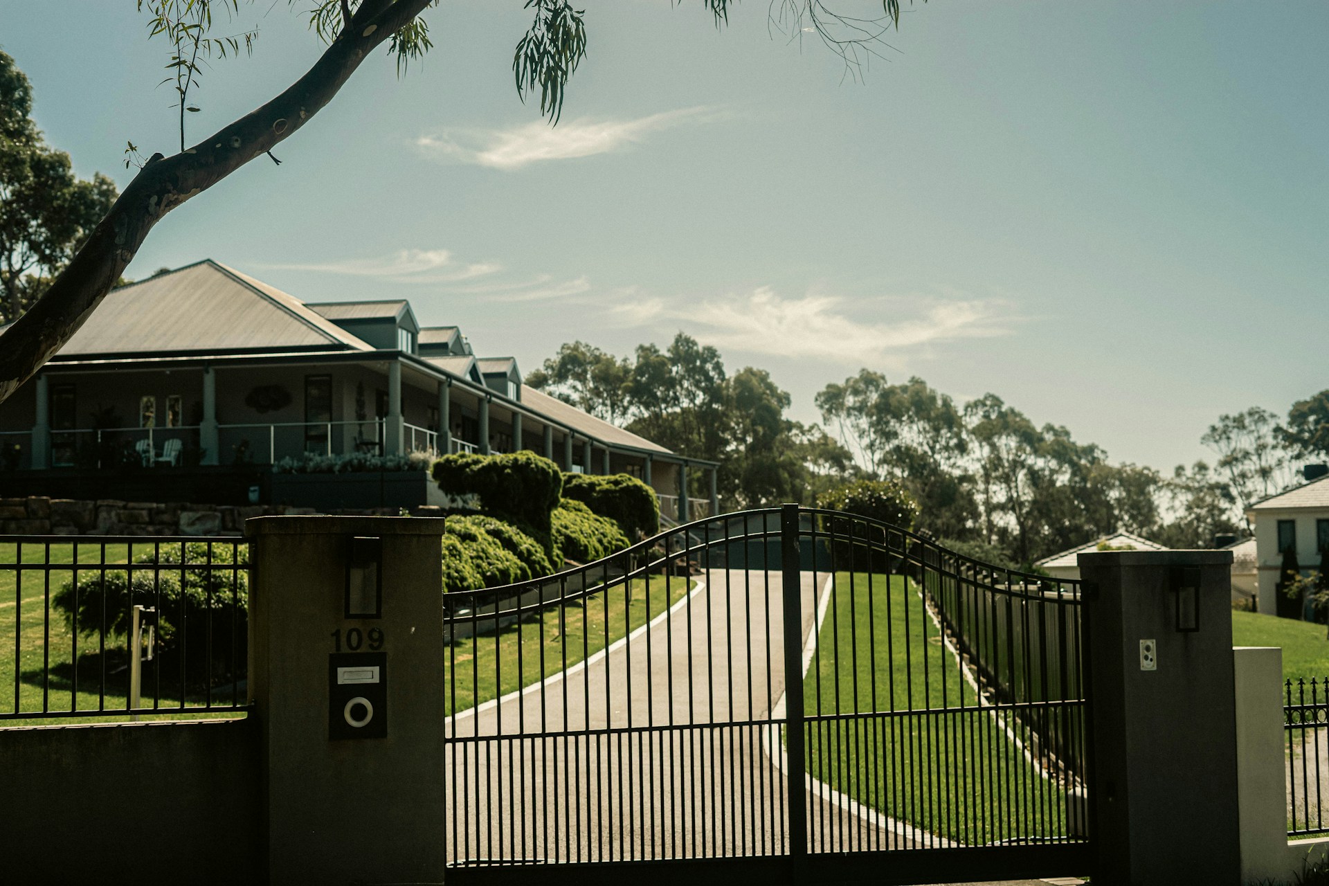 a gated driveway with a house in the background