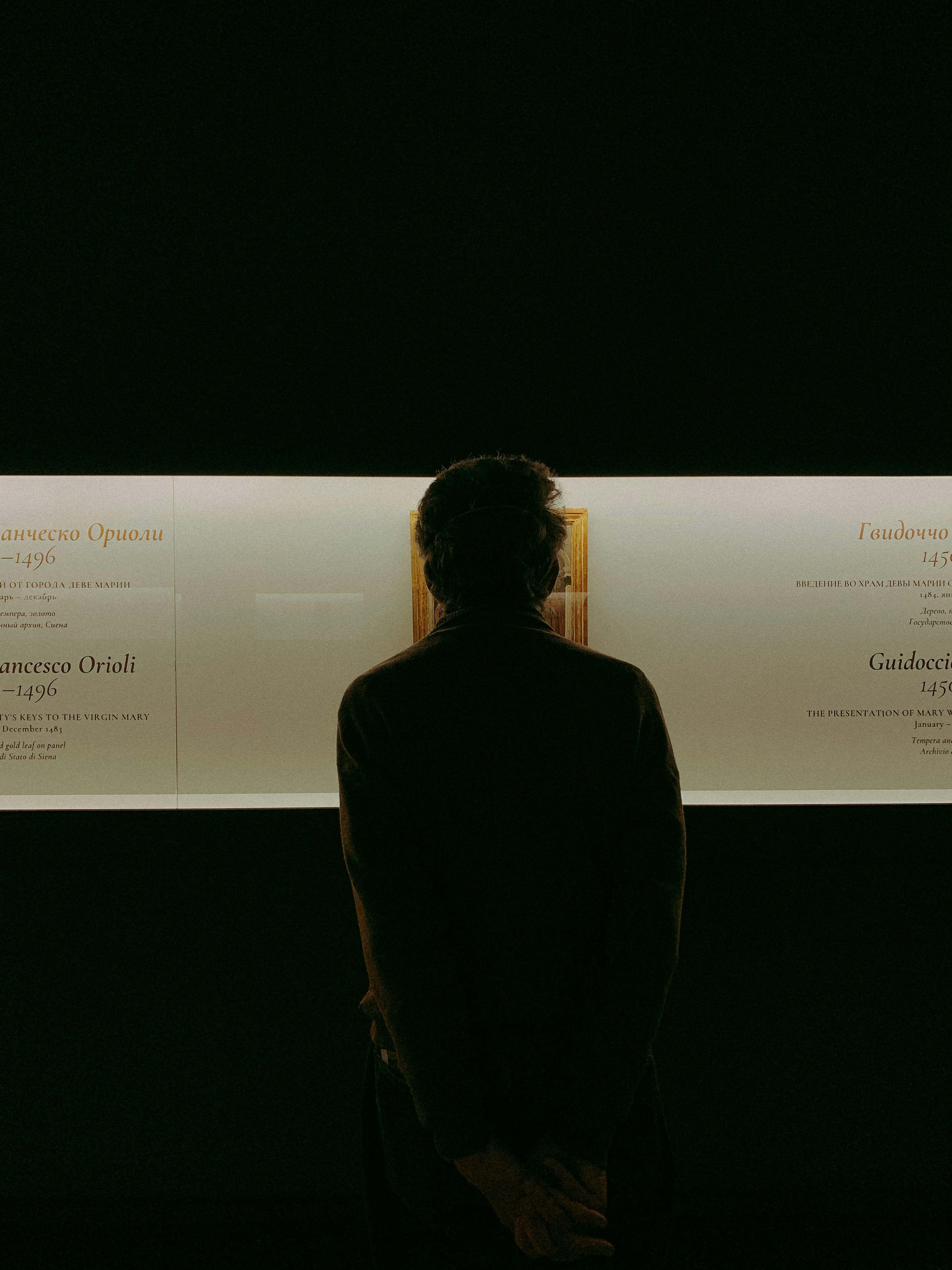 Una persona parada frente a una pared con carteles