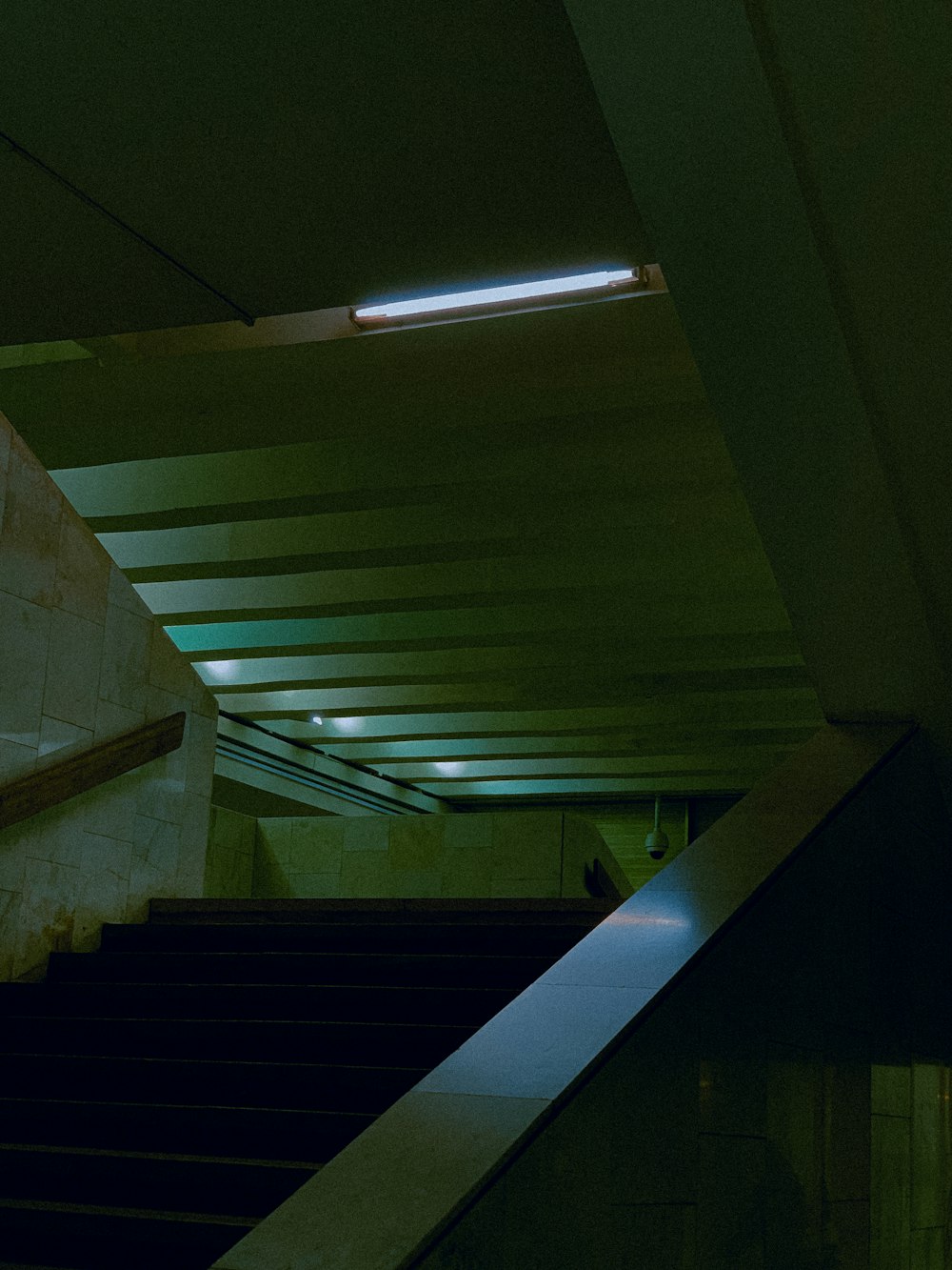 an escalator in a building with a light above it