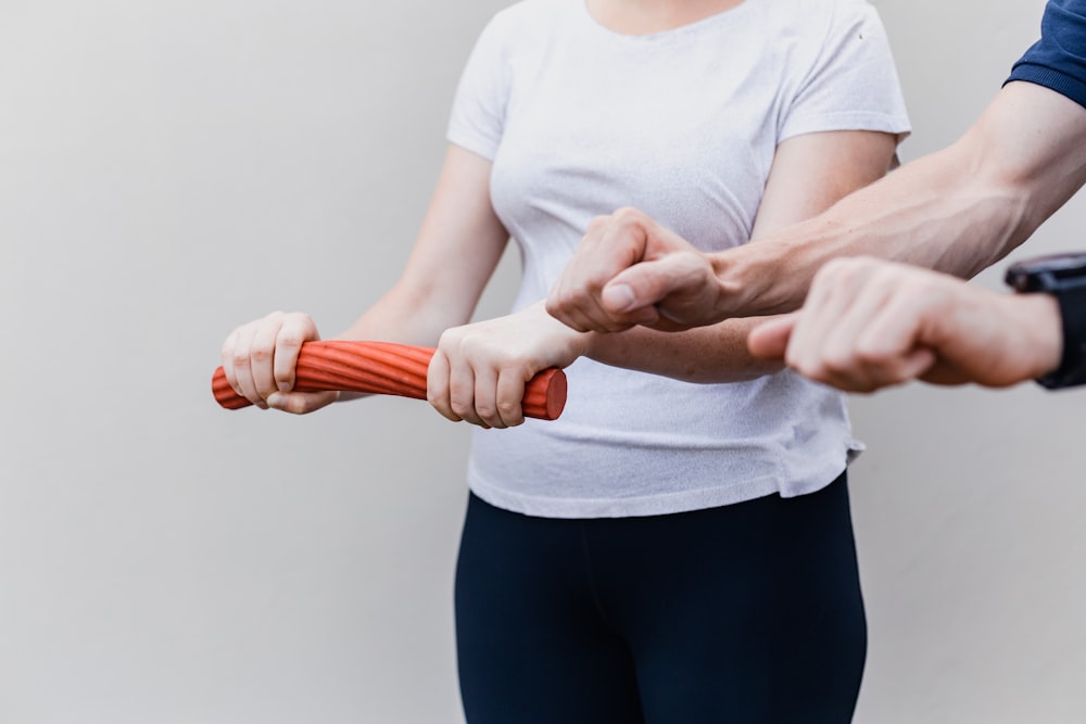 a woman holding a red handle while standing next to a man