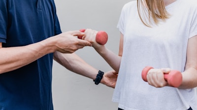 a man and a woman holding dumbs in their hands