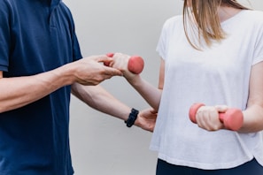 a man and a woman holding dumbs in their hands
