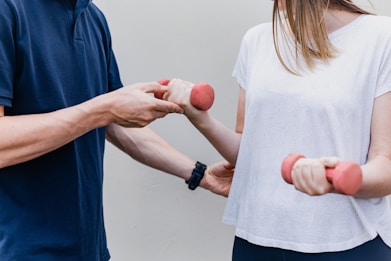 a man and a woman holding dumbs in their hands